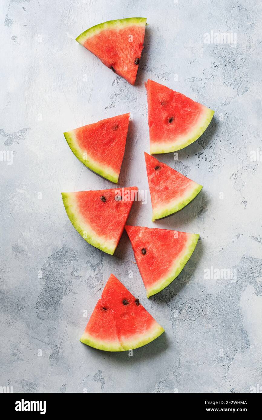 Slices of fresh watermelon with ice on a blue concrete background ...