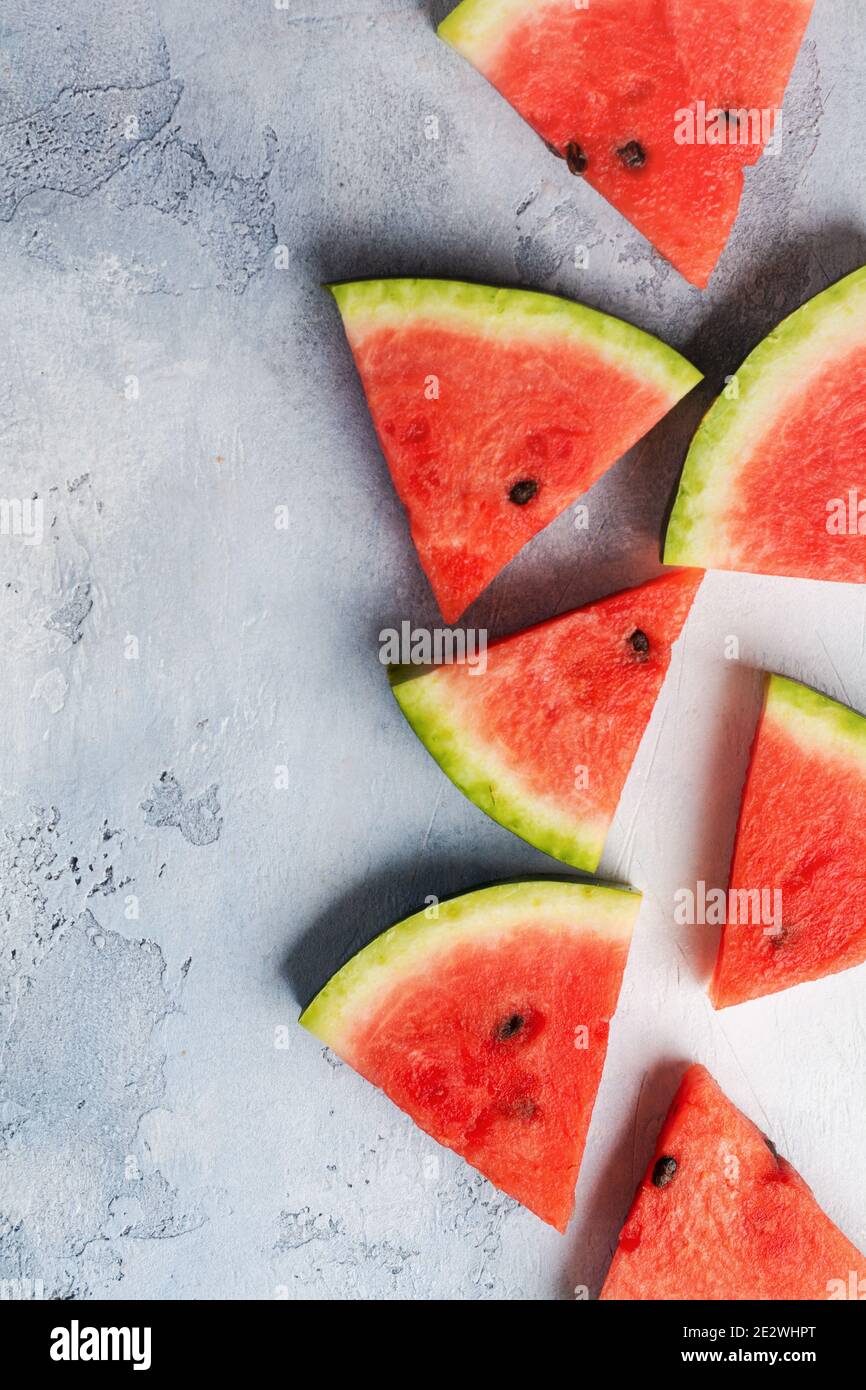 Slices of fresh watermelon with ice on a blue concrete background. Detox and vegetarian concept. Top view, copy space, banner Stock Photo