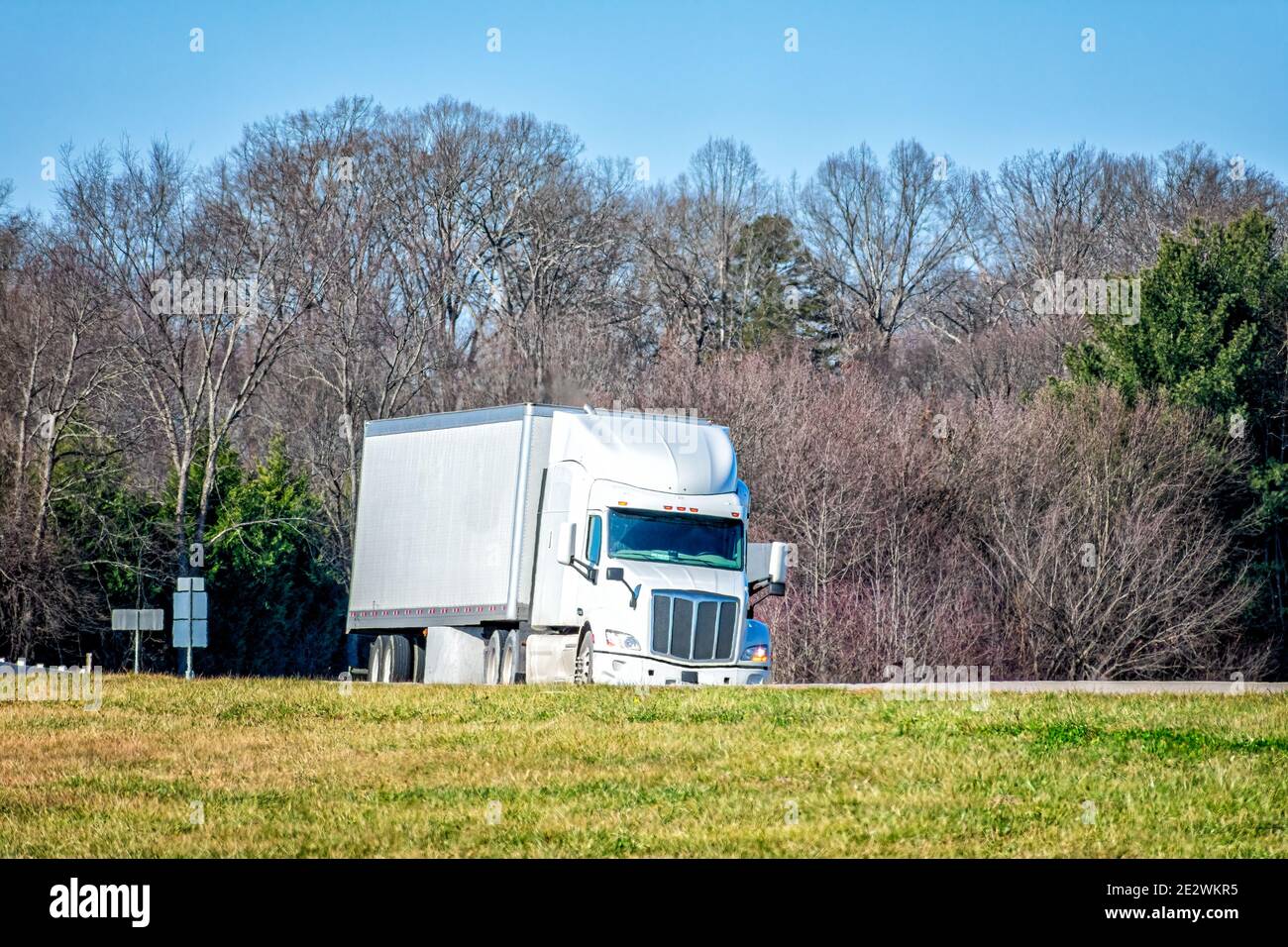 Horizontal shot of a generic white tractor trailer truck on a highway. Stock Photo