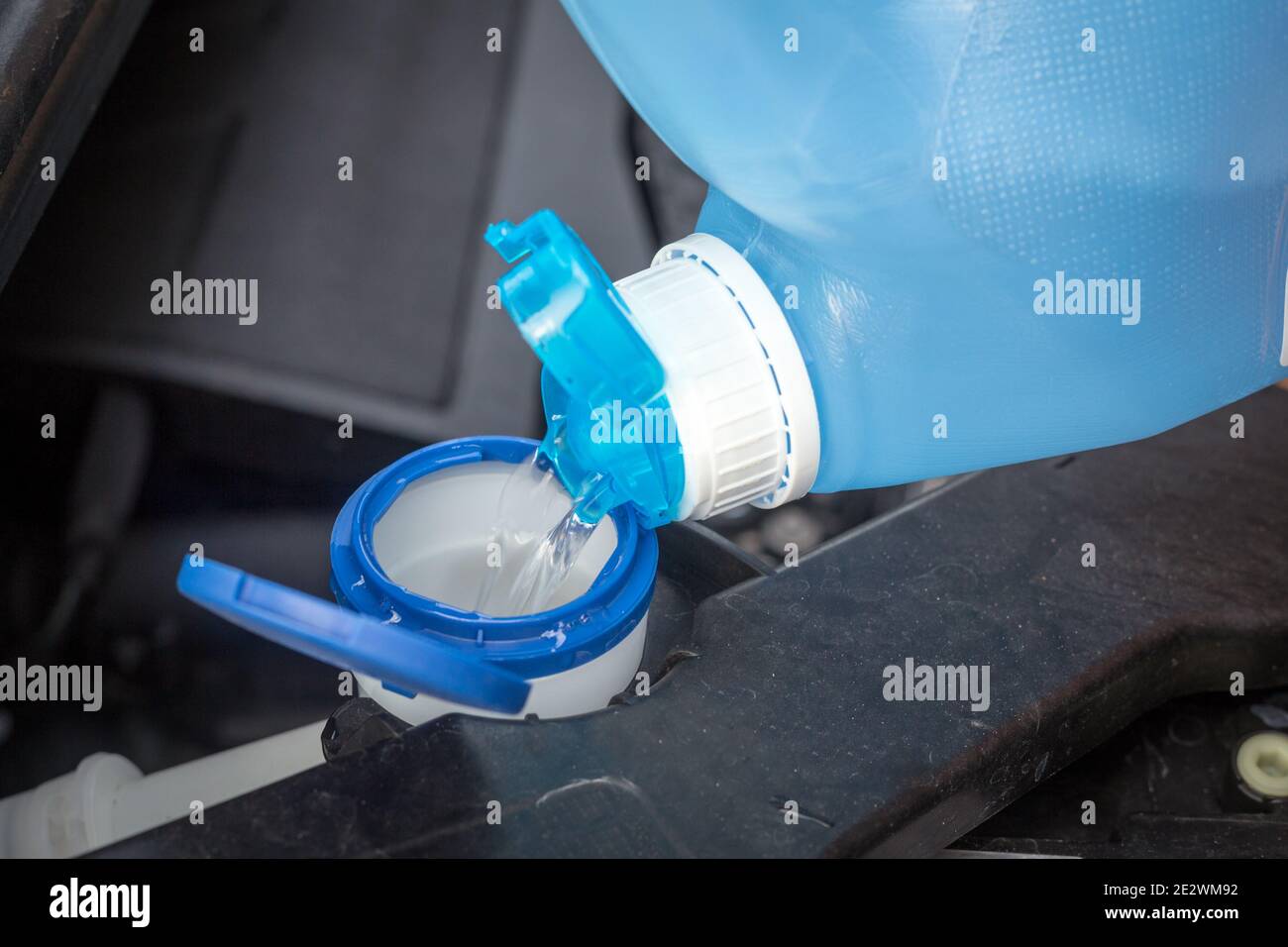 adding windscreen washer fluid in the car Stock Photo Alamy