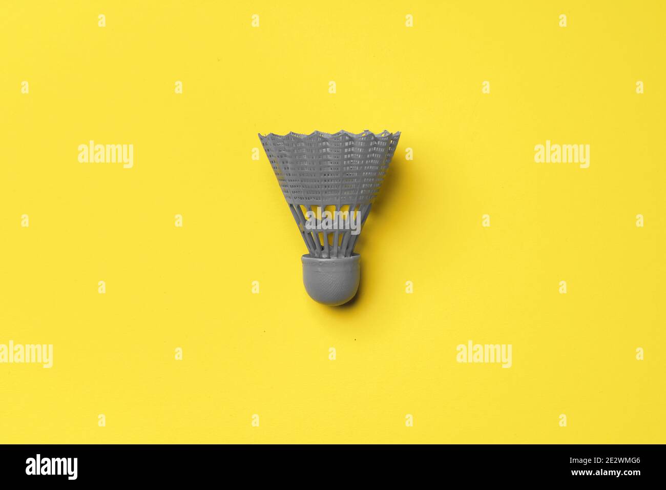 Gray shuttlecock on yellow background top view Stock Photo