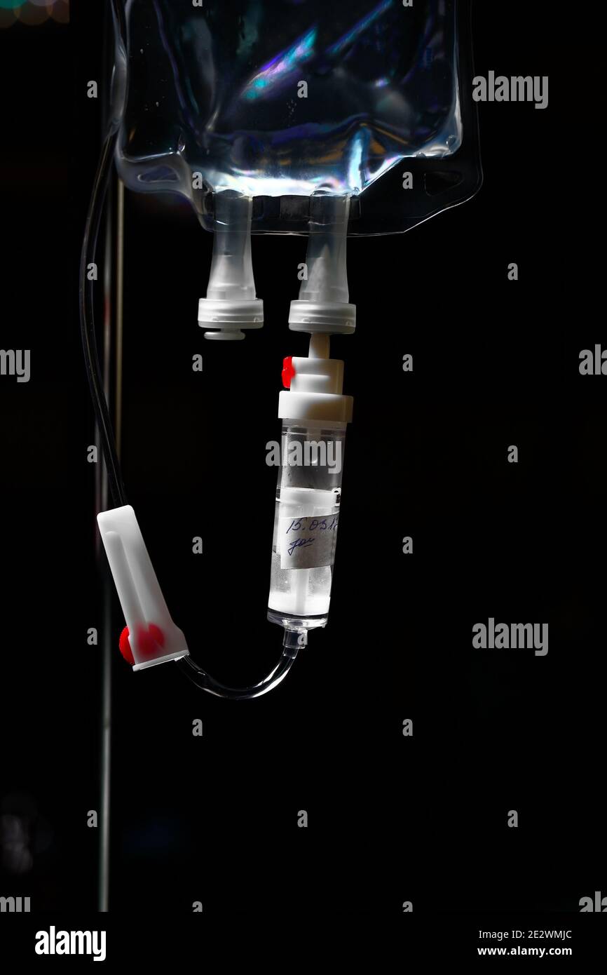 Medical drip bag on the dark background. Stock Photo