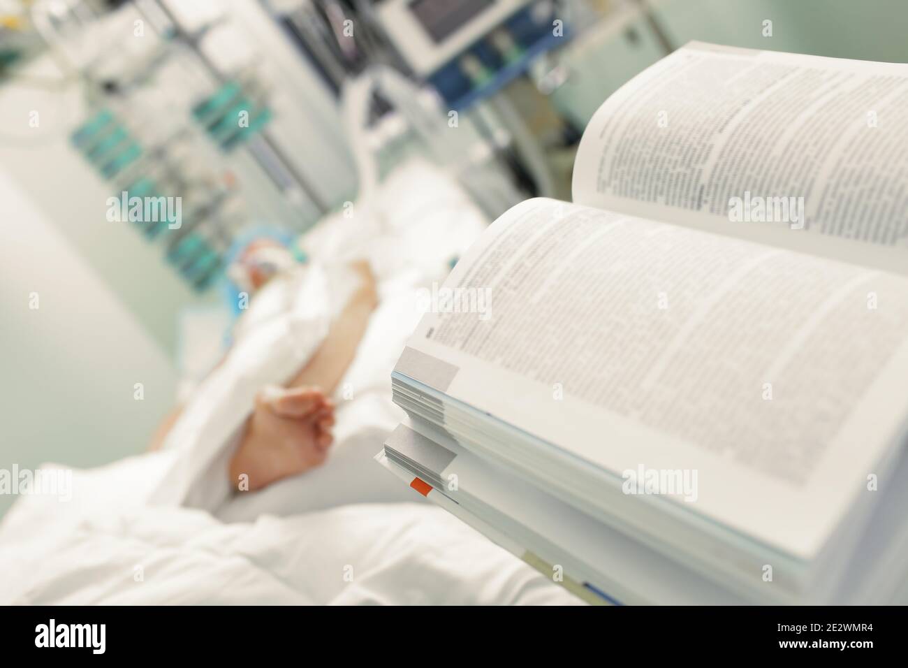 Open book on the background of critical patient in hospital. Stock Photo