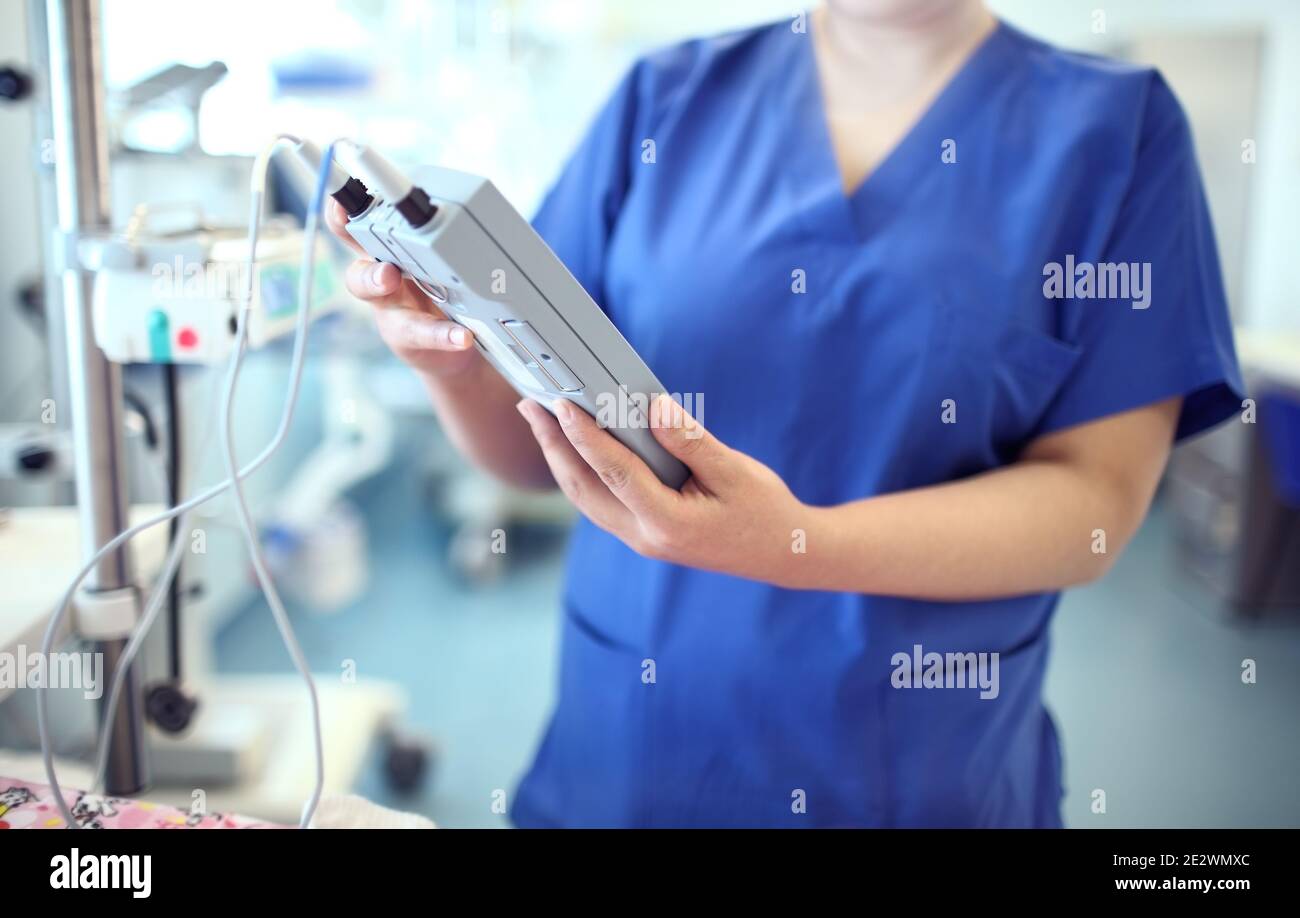 Female doctor adjust electronic medical device. Stock Photo