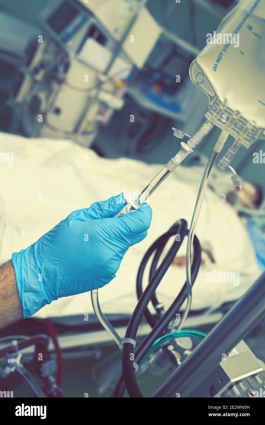 Hand holding valve of intravenous drip. Stock Photo