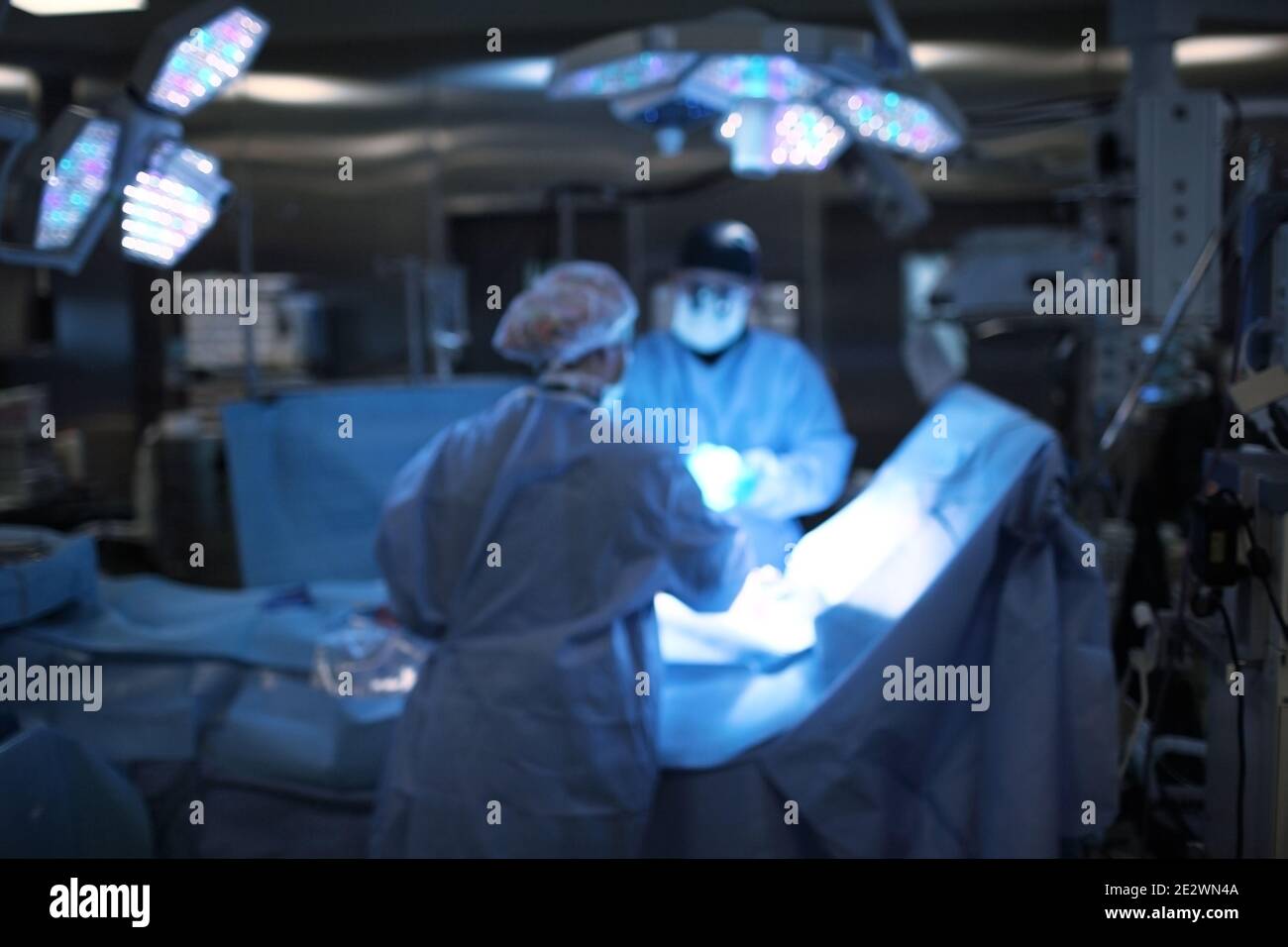 Working doctors during surgical operation, unfocused background. Stock Photo