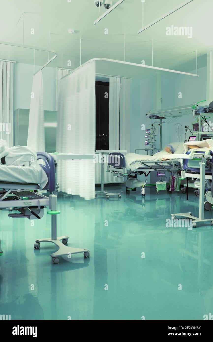 Interior of hospital ward with patients in beds. Stock Photo