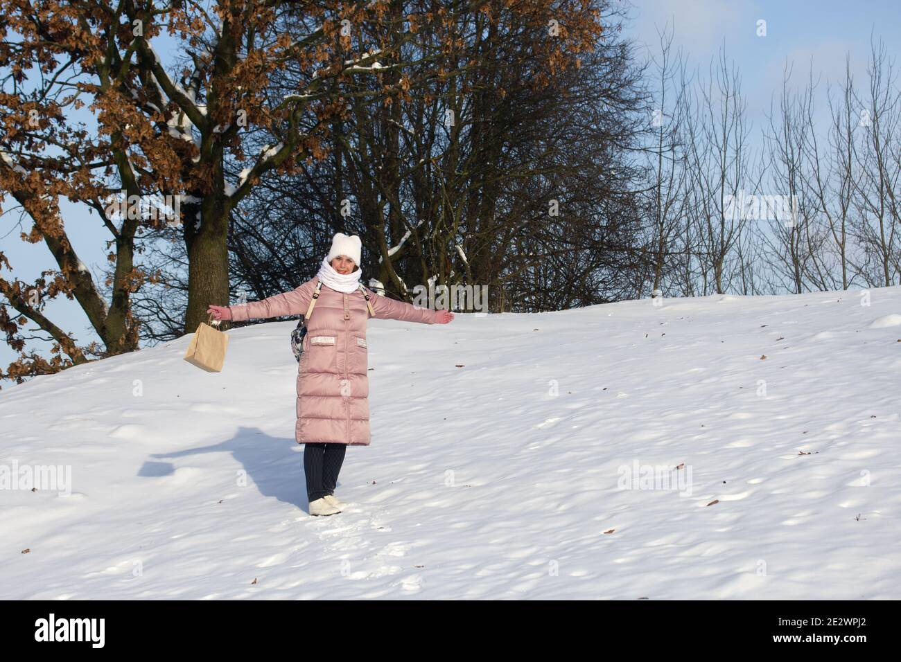Woman in winter clothes on a walk in the park. There is a lot of