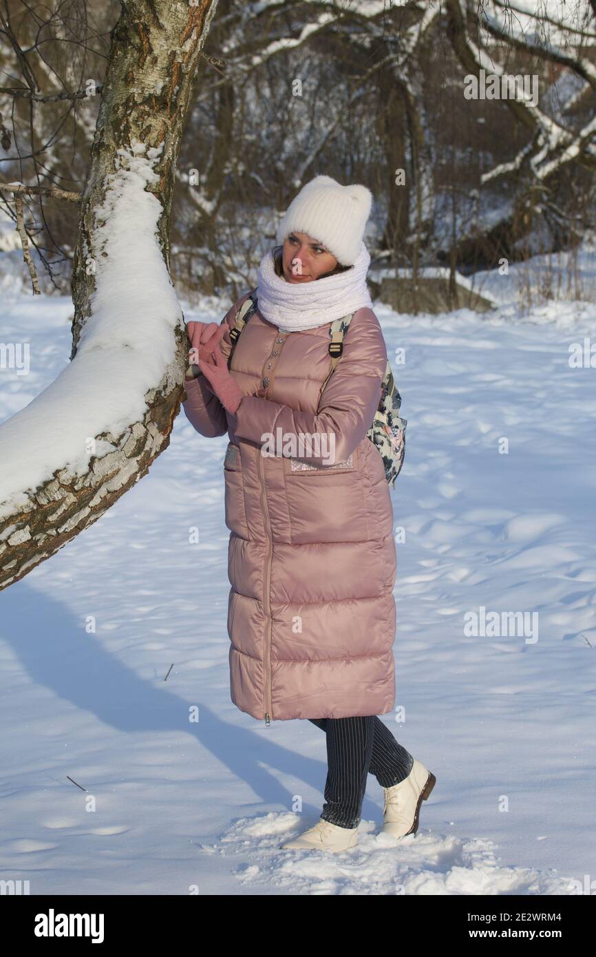 Woman in winter clothes on a walk in the park. There is a lot of snow ...