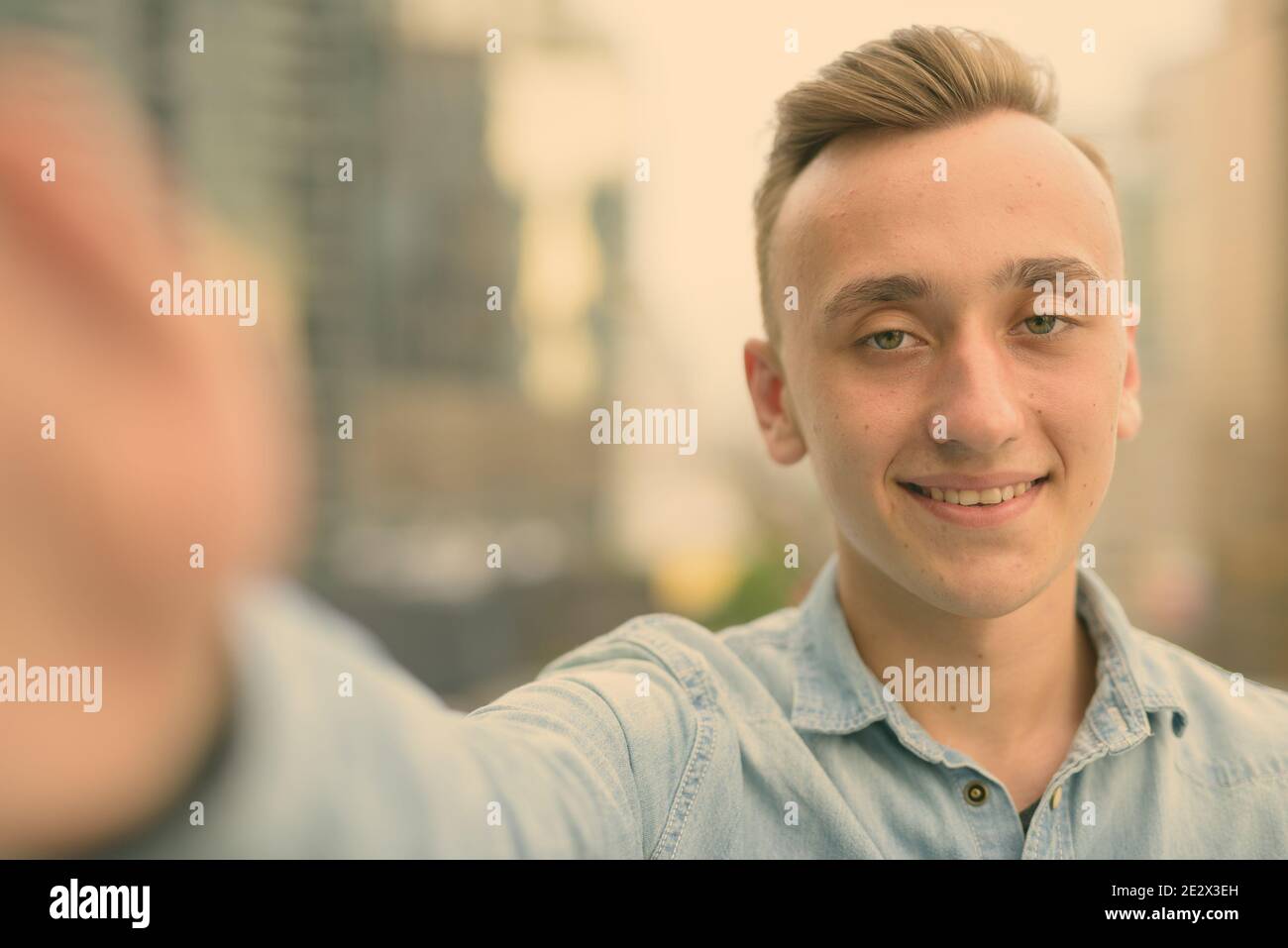 Young handsome man with blond hair against view of the city Stock Photo ...