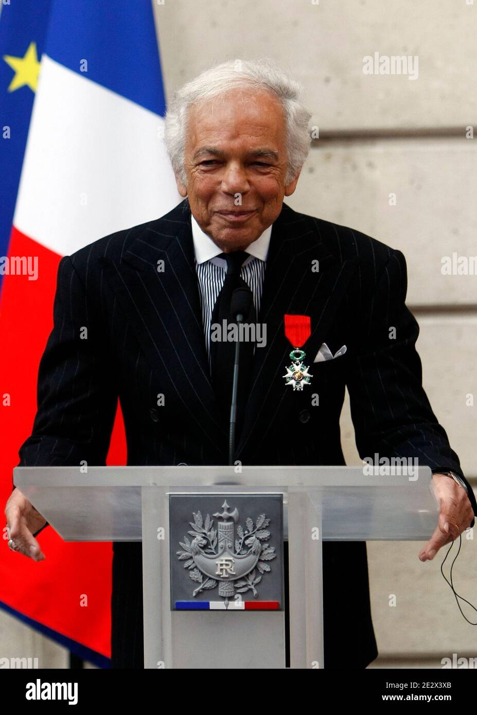 . fashion designer Ralph Lauren, left, delivers his speech after being  awarded Chevalier of the Legion of Honor, one of France's most prestigious  distinctions, by French President Nicolas Sarkozy, unseen, during a