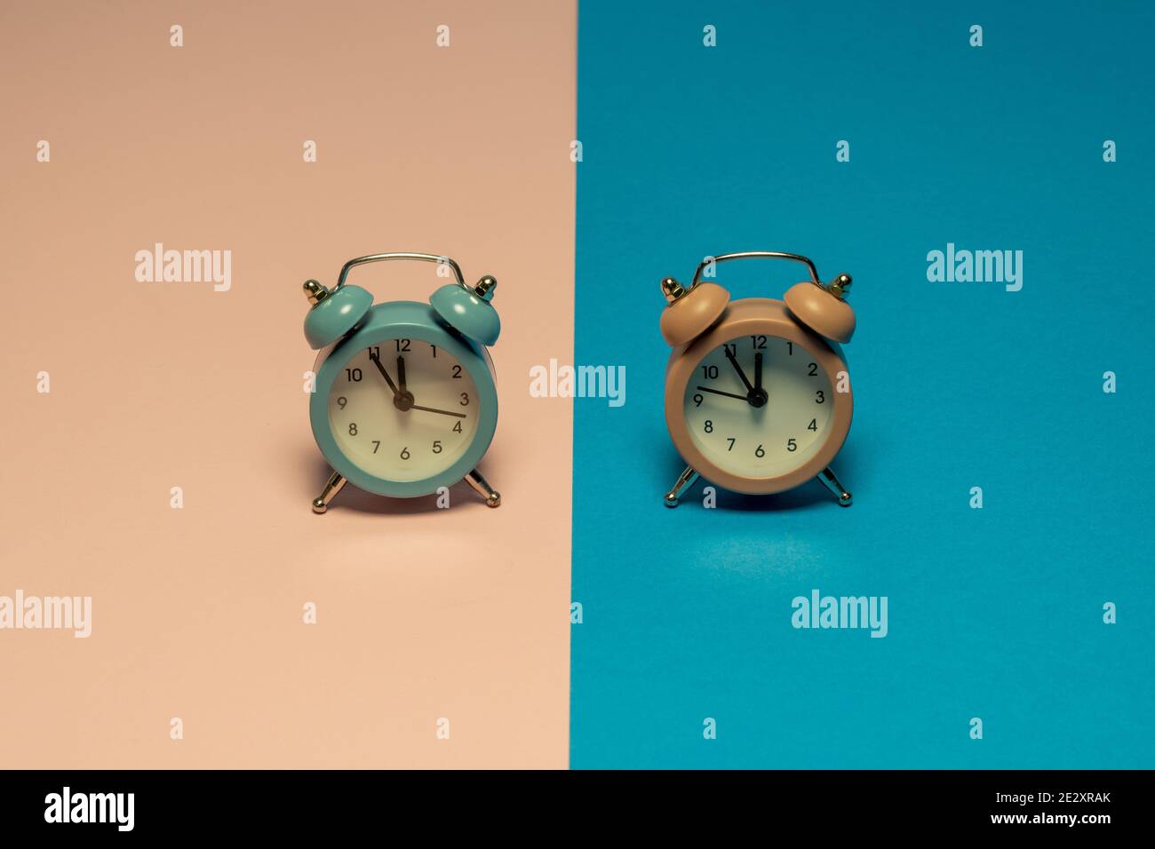 Pastel colors retro clocks that show five minutes to twelve. Dual color background Stock Photo
