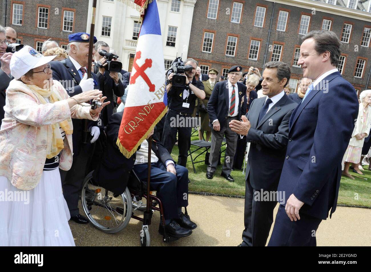 British Prime Minister David Cameron and French President Nicolas Sarkozy talk with Legion de Honeur recipients and World War II veterans during a parade at the Royal Chelsea Hospital in London, UK on June 18, 2010. Nicolas Sarkozy and World War II veterans visited London to mark the 70th anniversary of Charles de Gaulle's rousing radio appeal to his compatriots to resist the Nazi occupation. On June 18, 1940, four days after the fall of Paris and as the French government prepared to sign an armistice with Germany, the exiled military leader issued an impassioned appeal over the BBC airwaves t Stock Photo