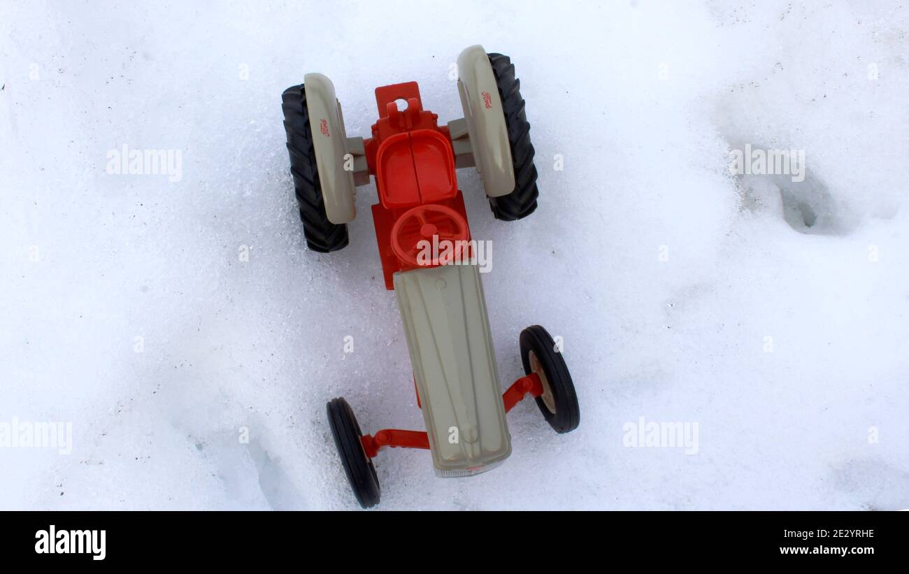 A Ertl 1/16 scale tractor at play in the snow. Stock Photo