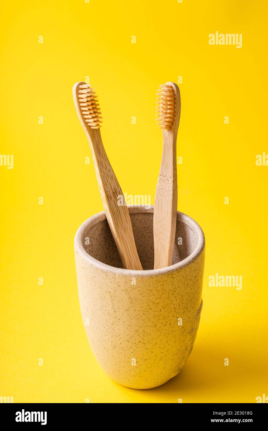 Cup with two Bamboo organic toothbrushes for dental hygiene on trendy ...