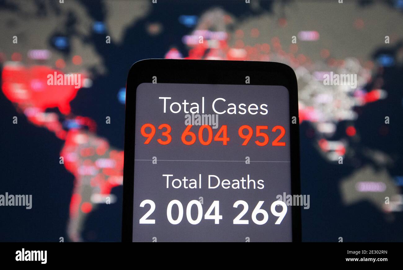In this photo illustration, Global cases and death toll are seen on a smartphone screen in front of the COVID-19 coronavirus dashboard by the Center for Systems Science and Engineering (CSSE) at Johns Hopkins University (JHU) website. Global death toll from the COVID-19 coronavirus in the world past 2 million people, according to media on 15 January 2021. Stock Photo