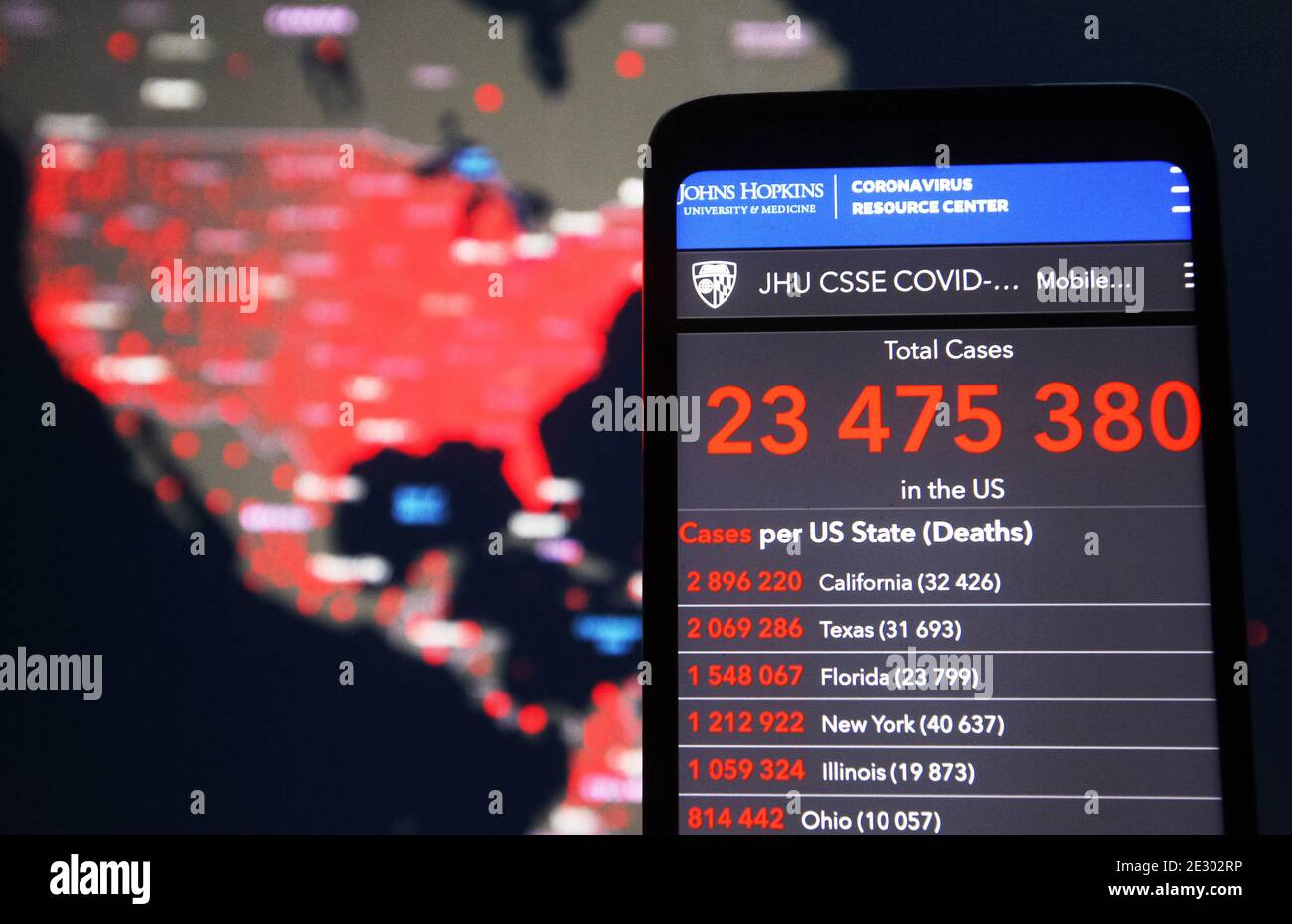 In this photo illustration, Total cases nubmer in the U.S. seen on a smartphone screen in front of the US map on the COVID-19 coronavirus dashboard by the Center for Systems Science and Engineering (CSSE) at Johns Hopkins University (JHU) website. Global death toll from the COVID-19 coronavirus in the world past 2 million people, according to media on 15 January 2021. Stock Photo