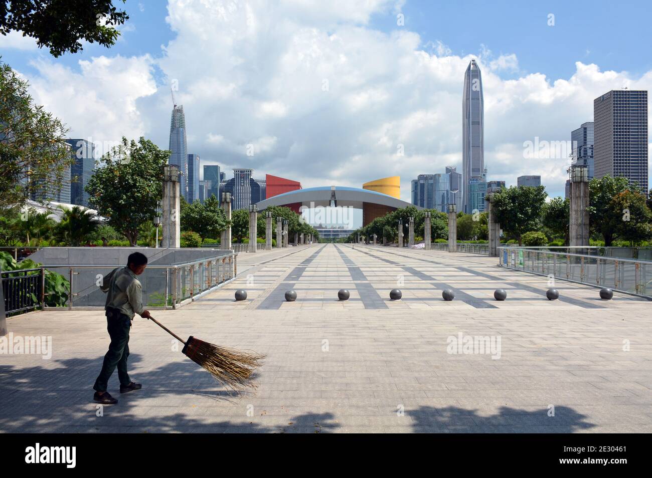 Looking towards the Shenzhen civic centre, one of the many cleaners sweeps to keep area clean. Finalist place in Shenzhen eye photo competition 2020 Stock Photo