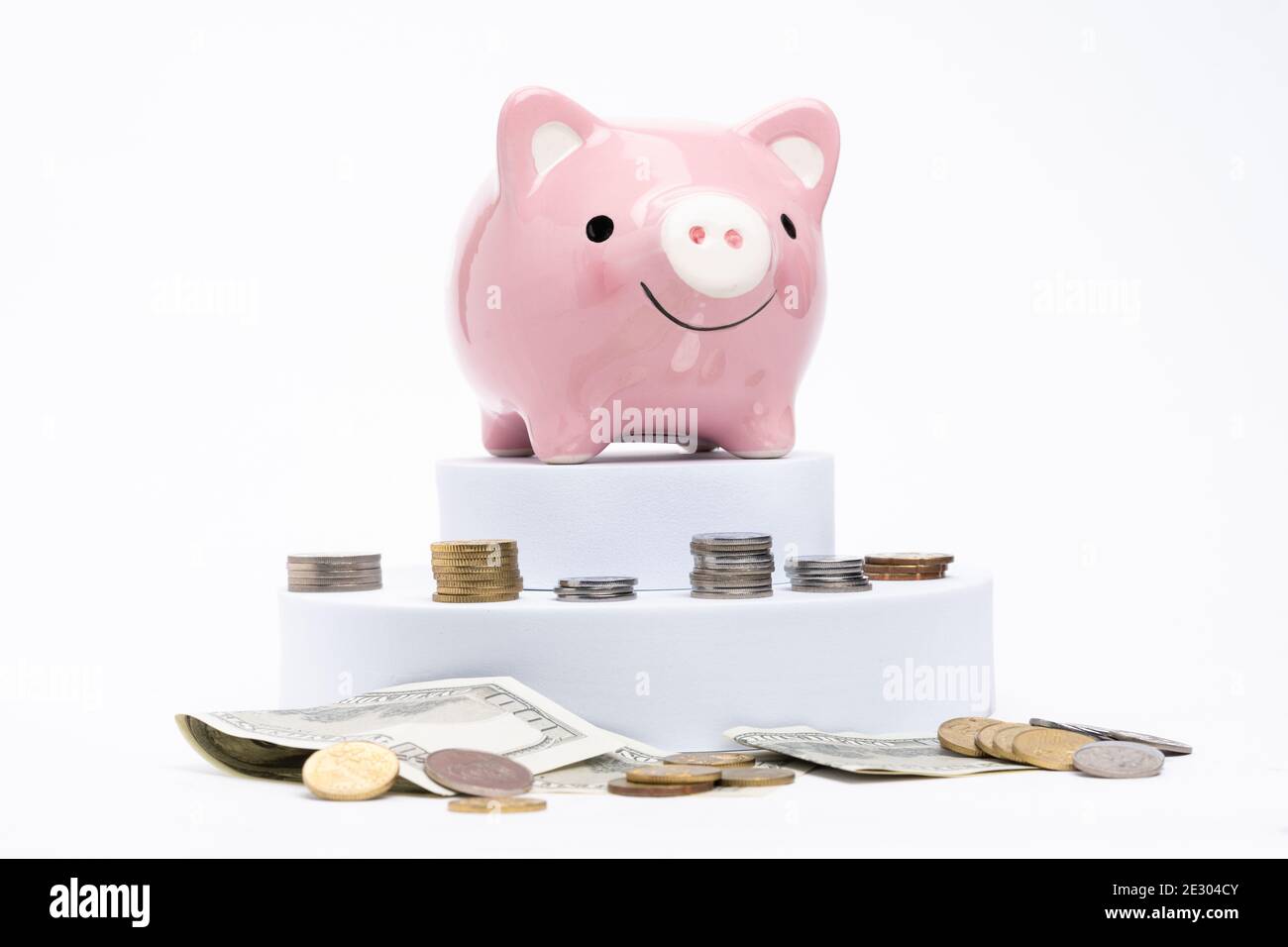 Piggy bank with scattered coins on white background Stock Photo - Alamy