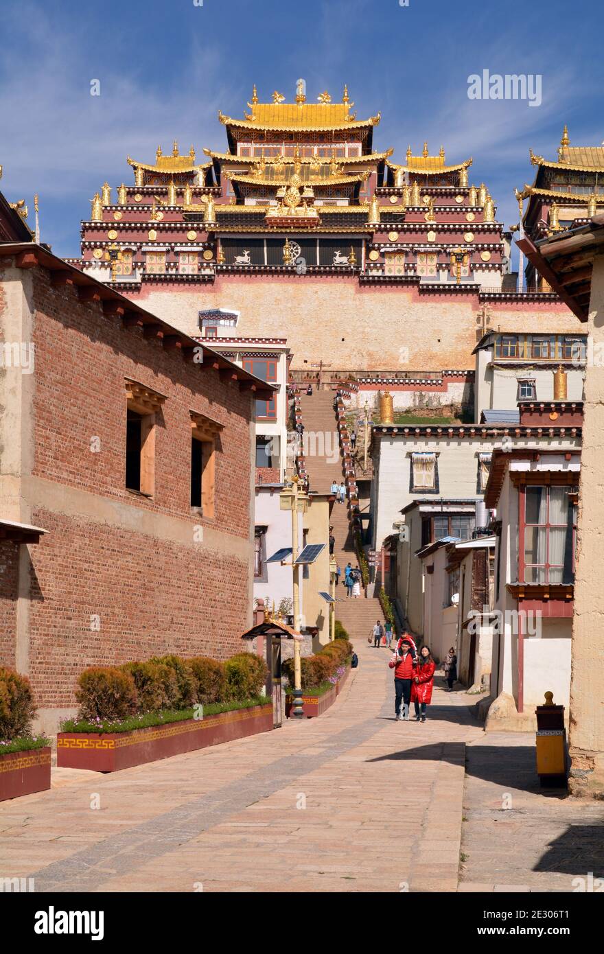 Sumtseling monastery high above the city of Shangri La, Yunnan. Tibetan buddhist style with gold topped buildings. Entrance with steps going up. Stock Photo