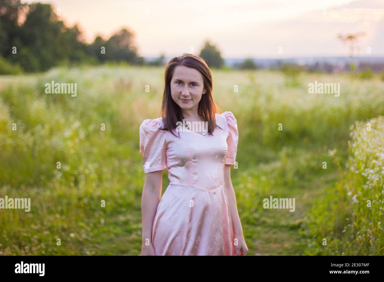 girl standing in the field in a pink dress Stock Photo - Alamy