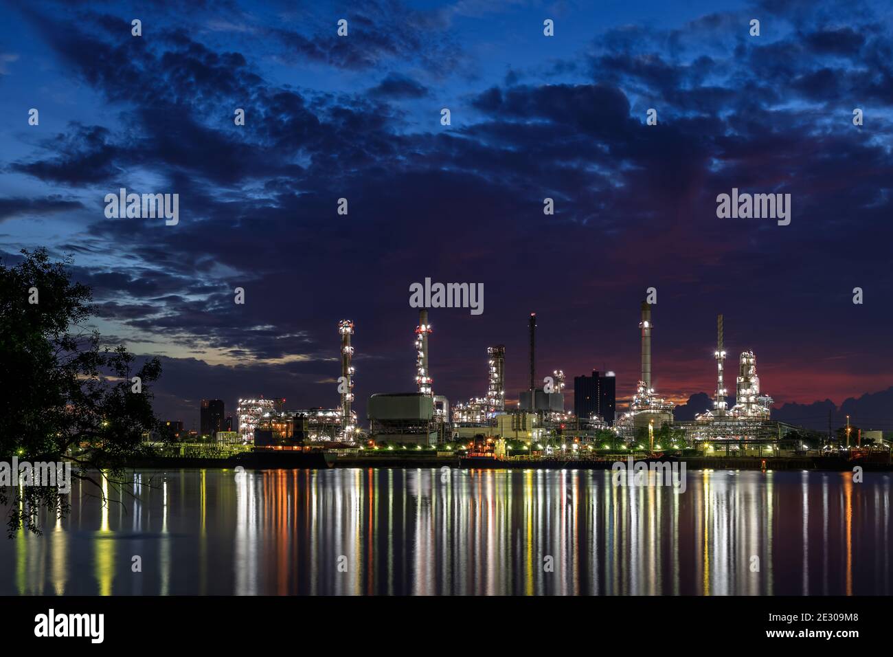 Oil and gas refinery plant factory with refection on river at twilight. petrochemical and energy industry concept. Stock Photo