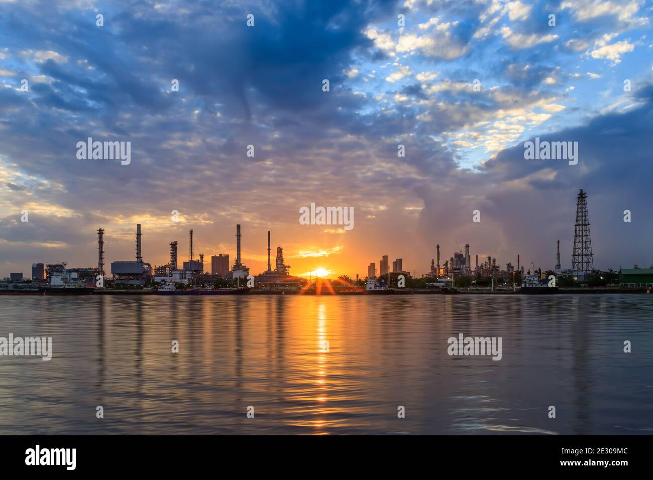 Oil and gas refinery plant factory with refection on river at sunrise. petrochemical and energy industry concept. Stock Photo