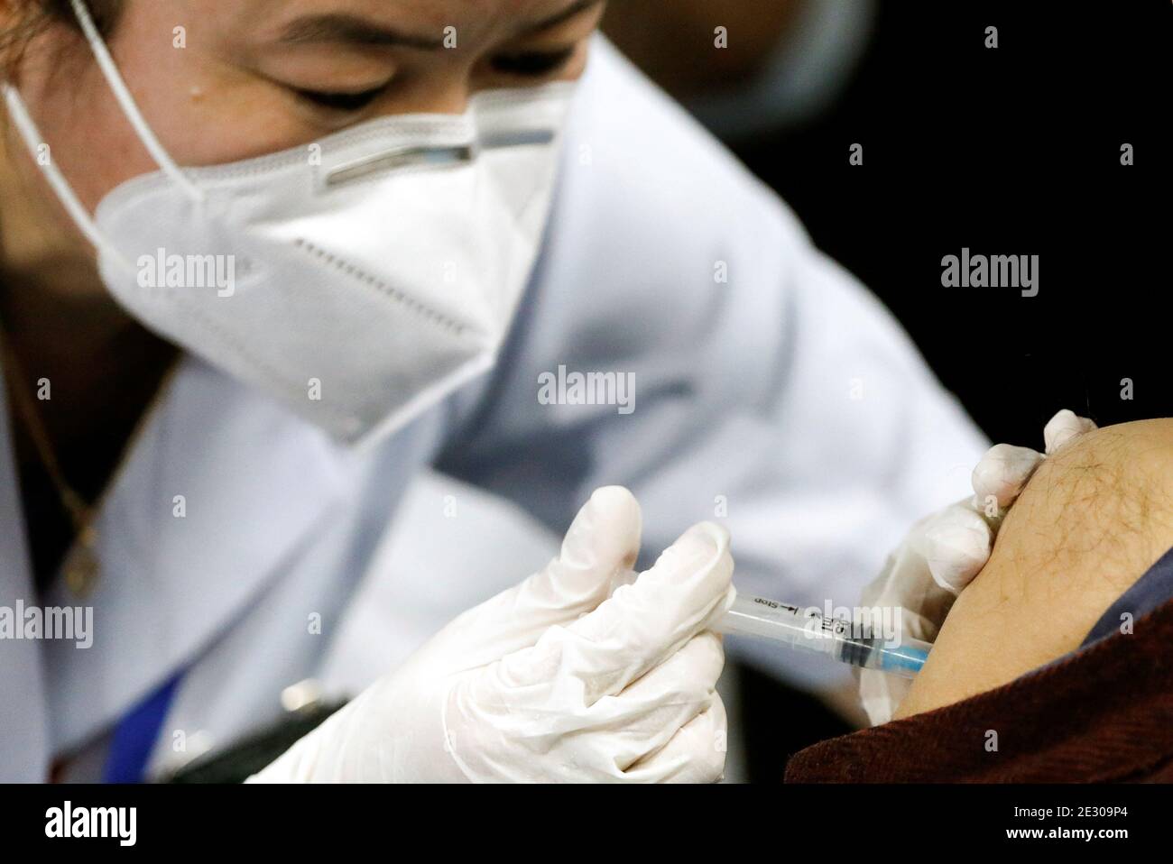 A healthcare worker receives a Bharat Biotech's COVID-19 vaccine called COVAXIN, during the coronavirus disease (COVID-19) vaccination campaign at All India Institute of Medical Sciences (AIIMS) hospital in New Delhi, India, January 16, 2021. REUTERS/Adnan Abidi Stock Photo