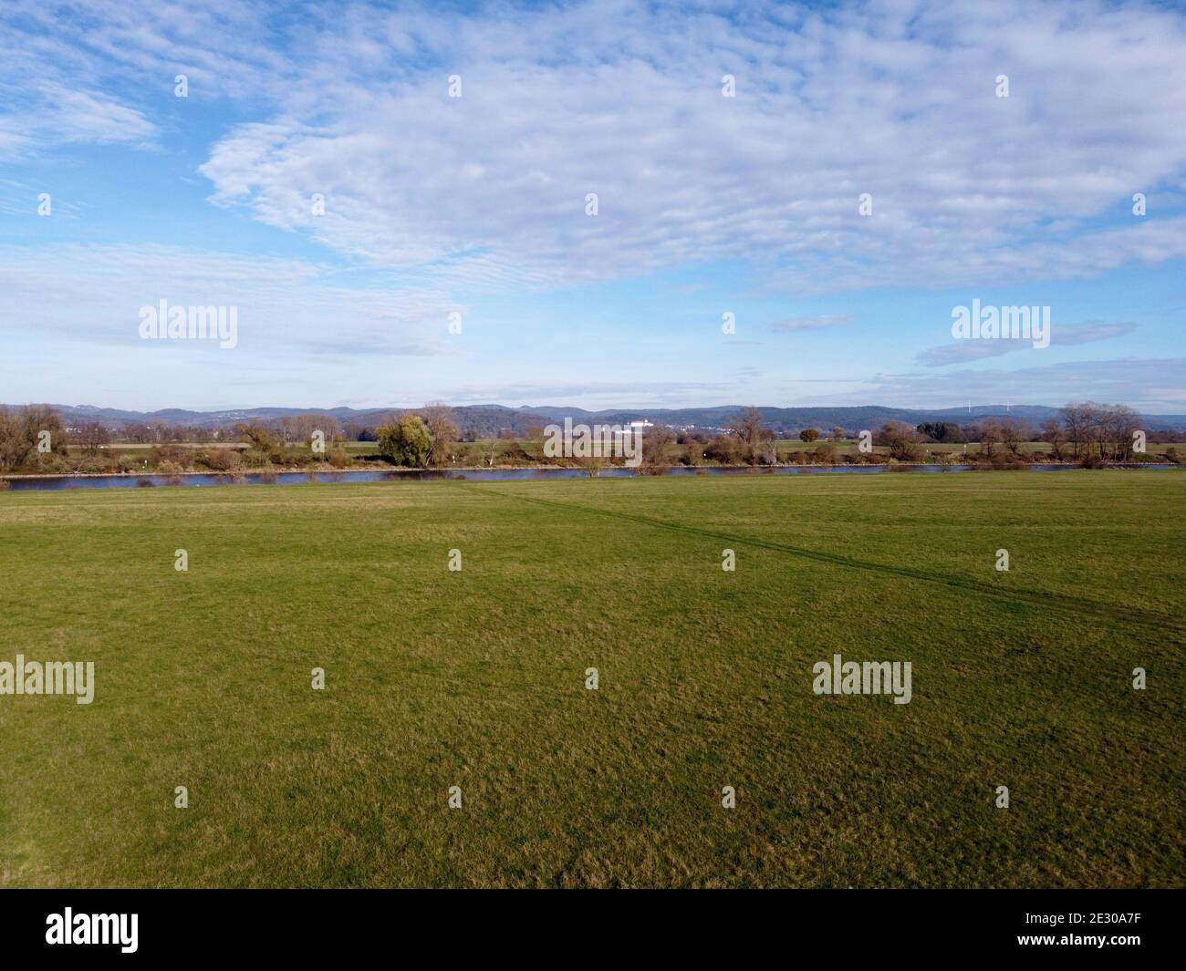 Green field under cloudy sky Stock Photo - Alamy