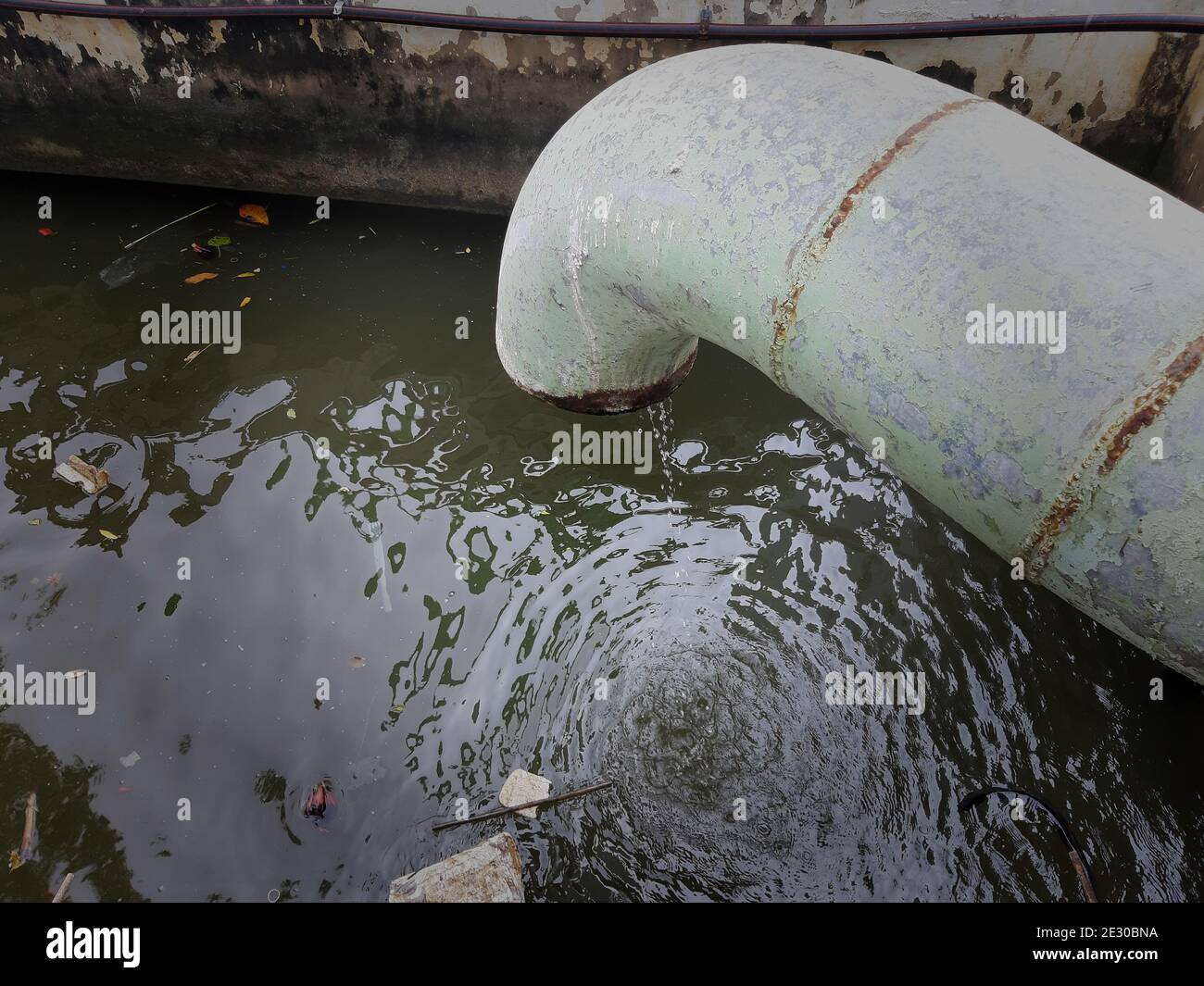 Waste pipe or drainage polluting the environment. The wastewater pipe from the village into the canal. Stock Photo