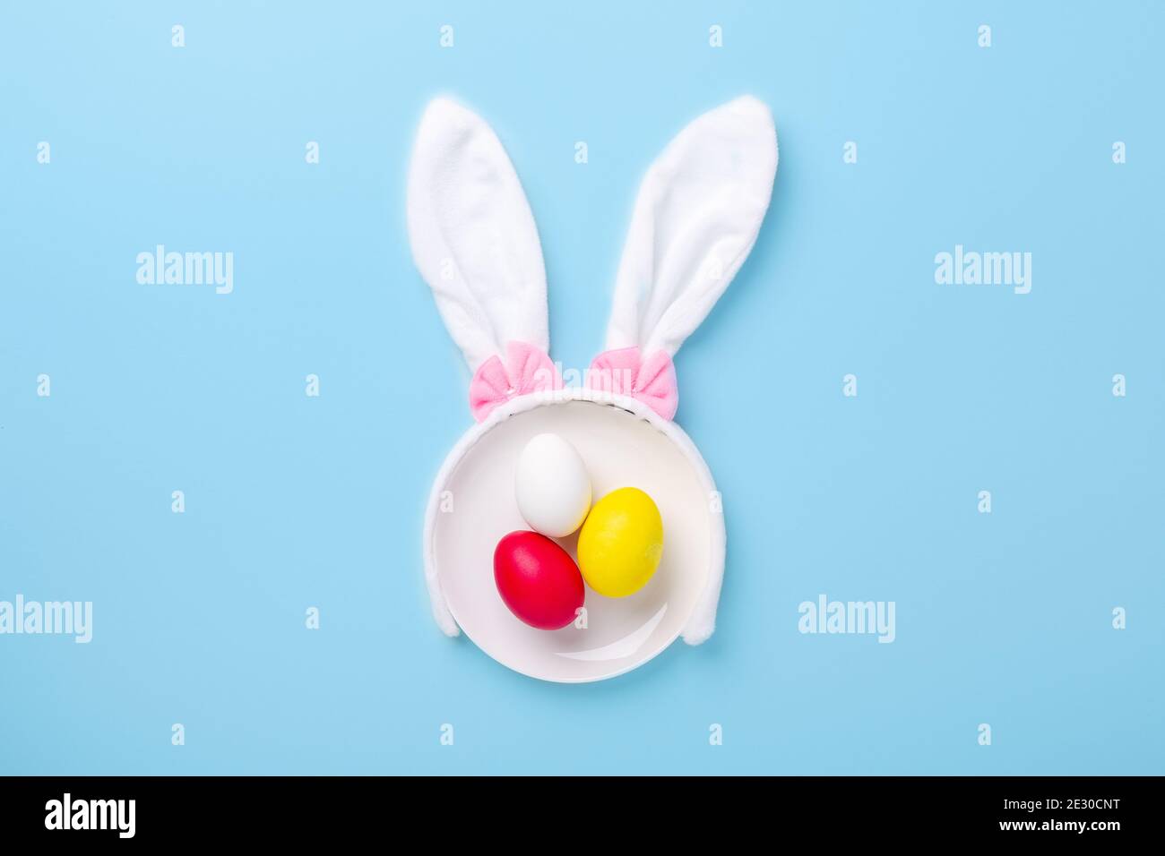 Creative Easter composition. Easter eggs and bunny ears on blue background. Copy space - Image Stock Photo