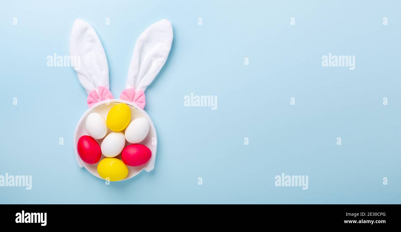 Creative Easter composition. Easter eggs and bunny ears on blue background. Copy space - Image Stock Photo