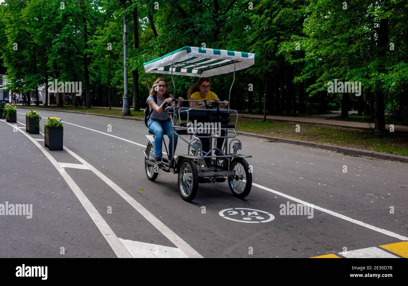 May 30, 2019, Moscow, Russia. Two girls ride a cycle rickshaw in Soklniki Park in Moscow. Stock Photo