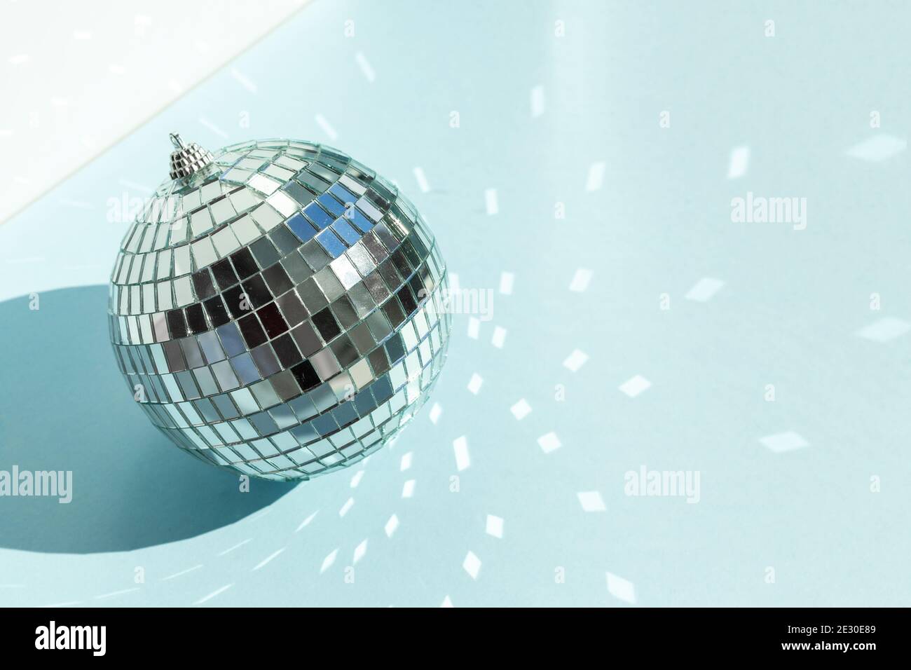 Shining disco ball on blue background. Disco ball with bright rays