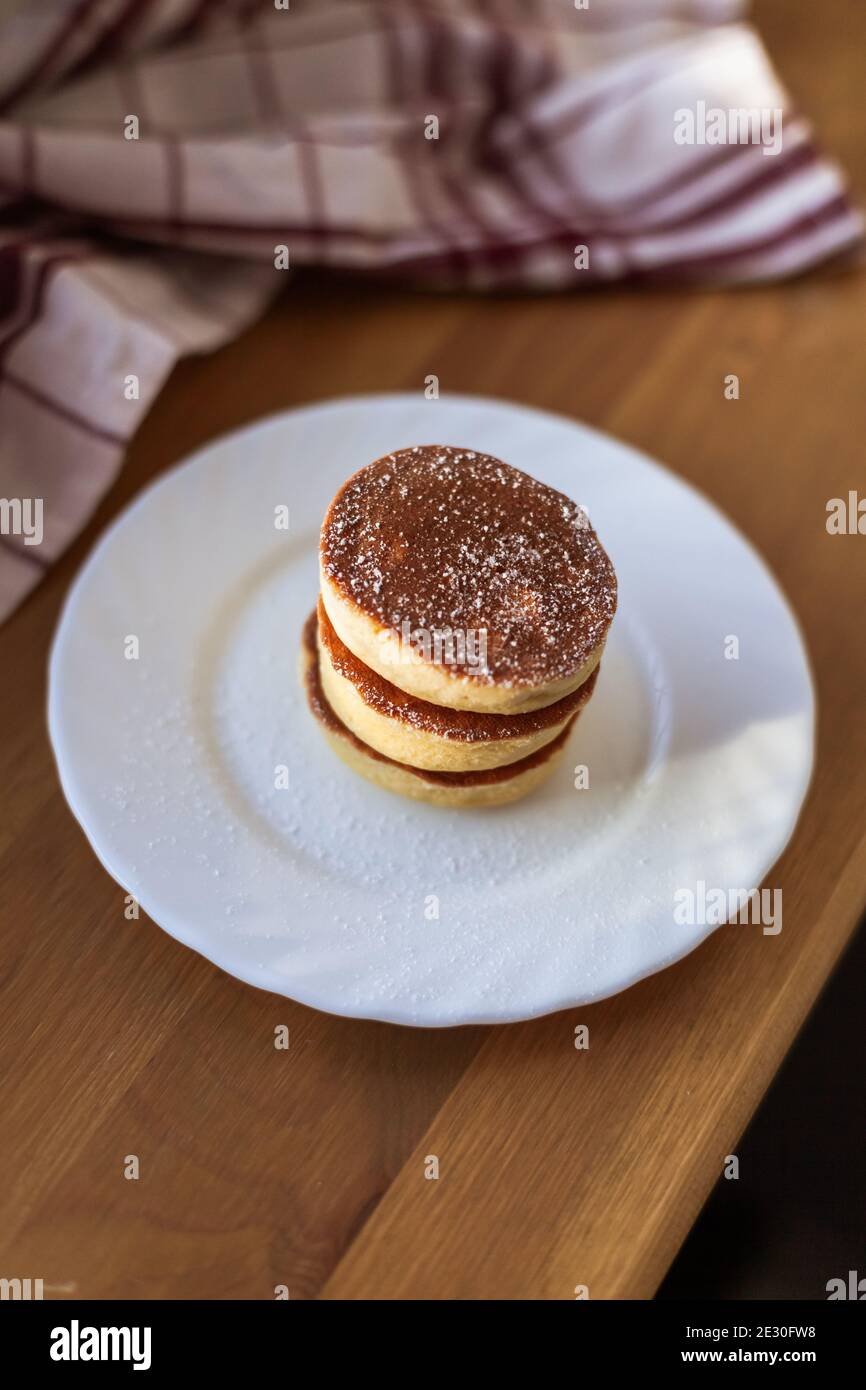 Homemade Fluffy Pancake, almond, coconut flour, closeup, on white plate with sweet powder, cotton towel. Japanese Style Dessert. carbfree Ketogenic Stock Photo