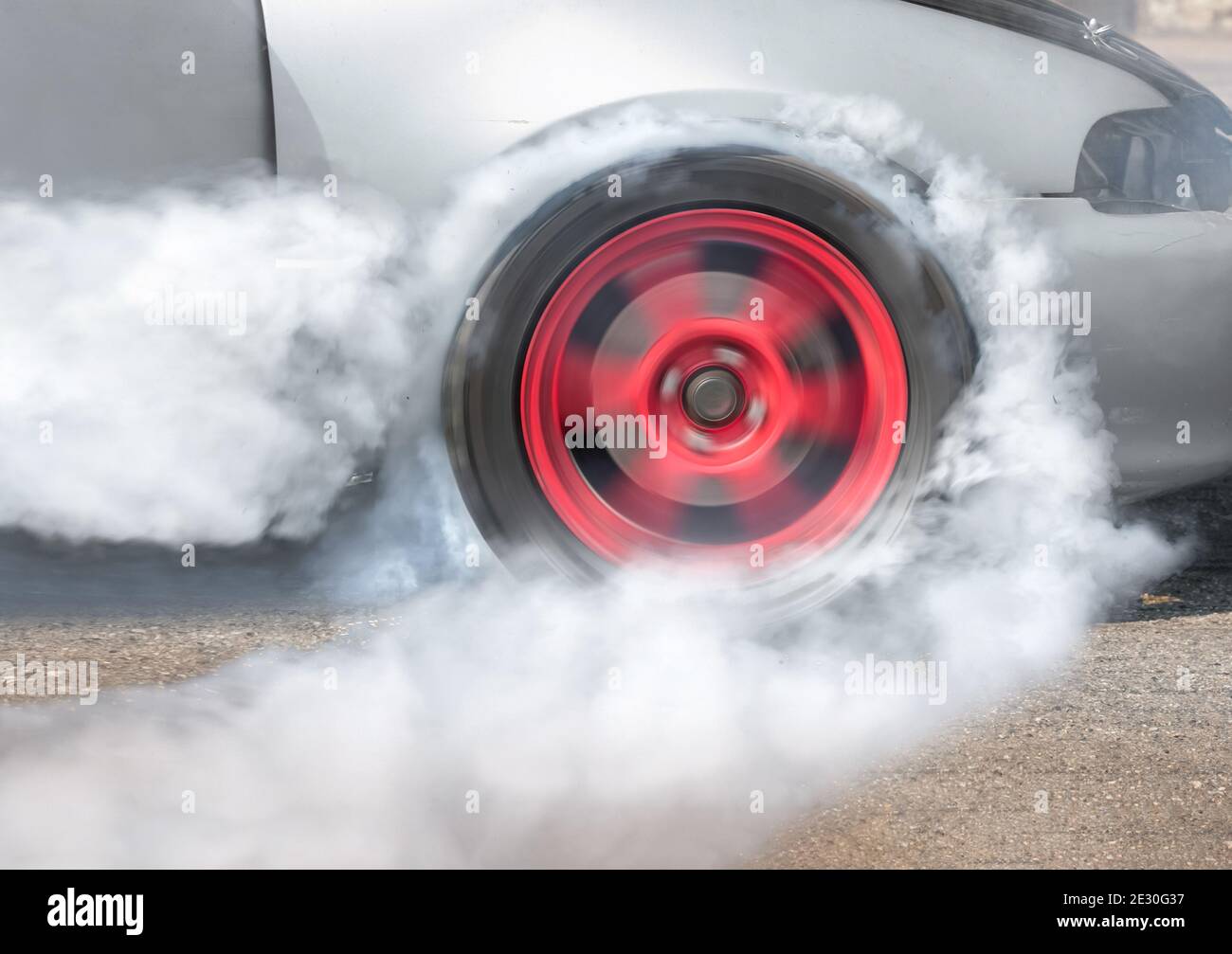 Drag racing car burns rubber off its tires in preparation for the race ...