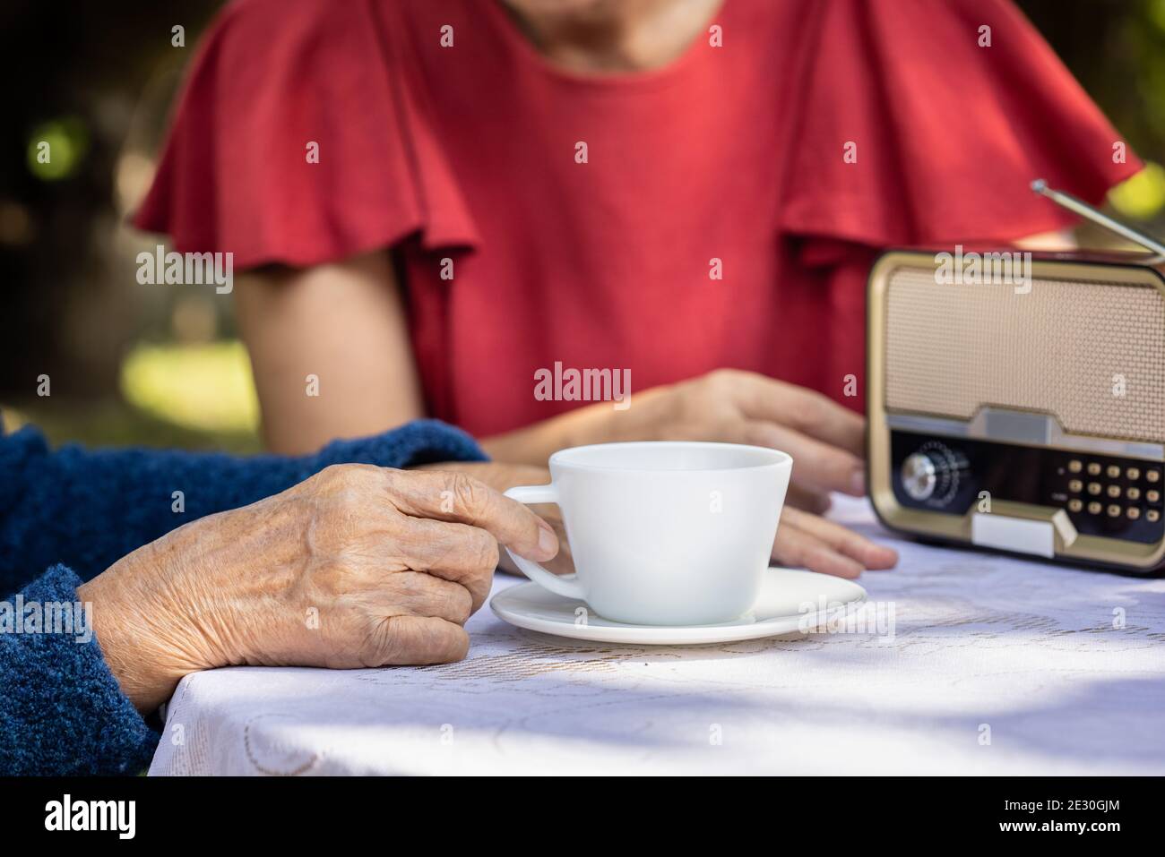 Senior woman relaxing with daughter  in backyard. Stock Photo