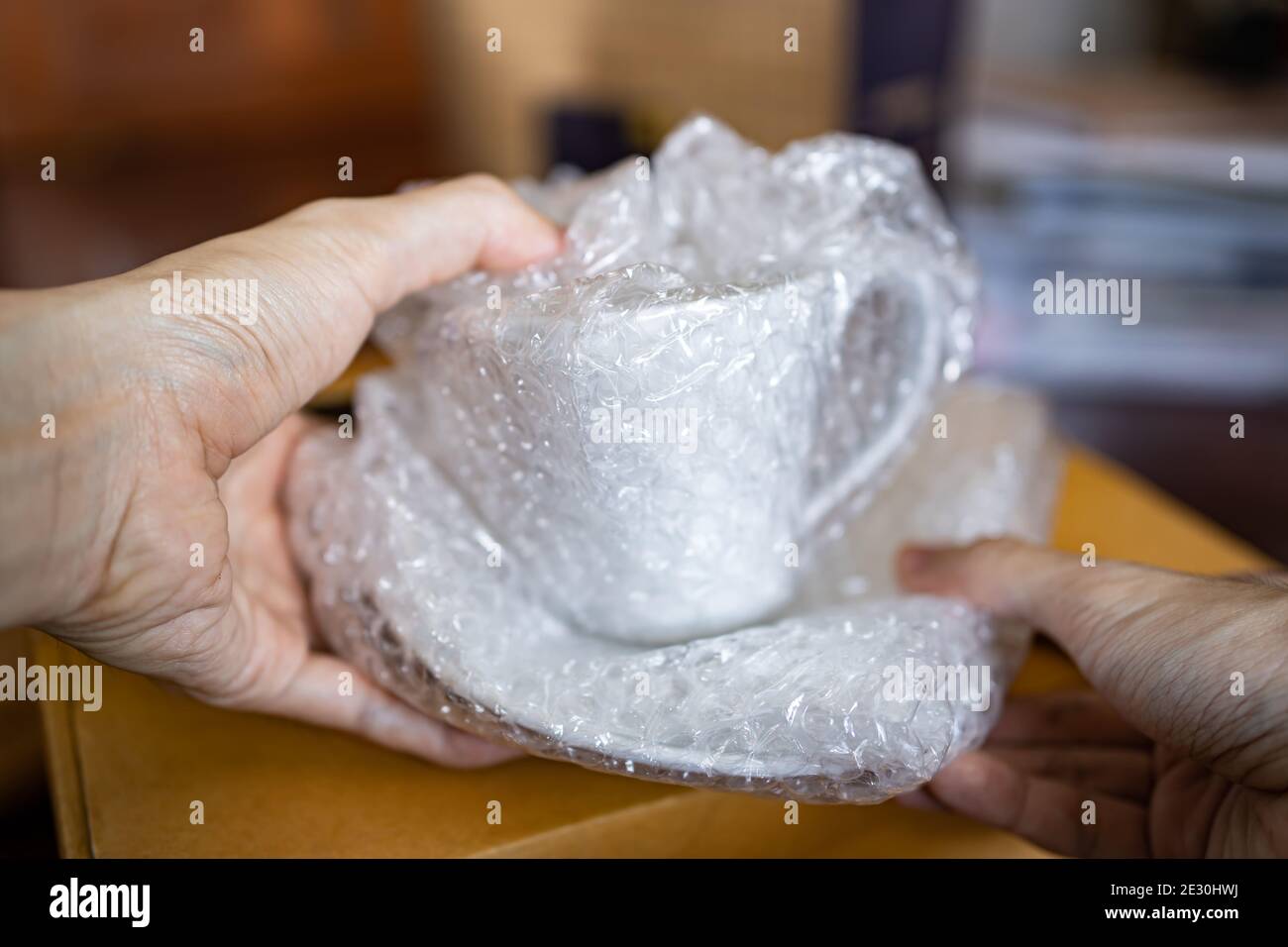 Wrapping a ceramic cup with bubble wrap Stock Photo Alamy