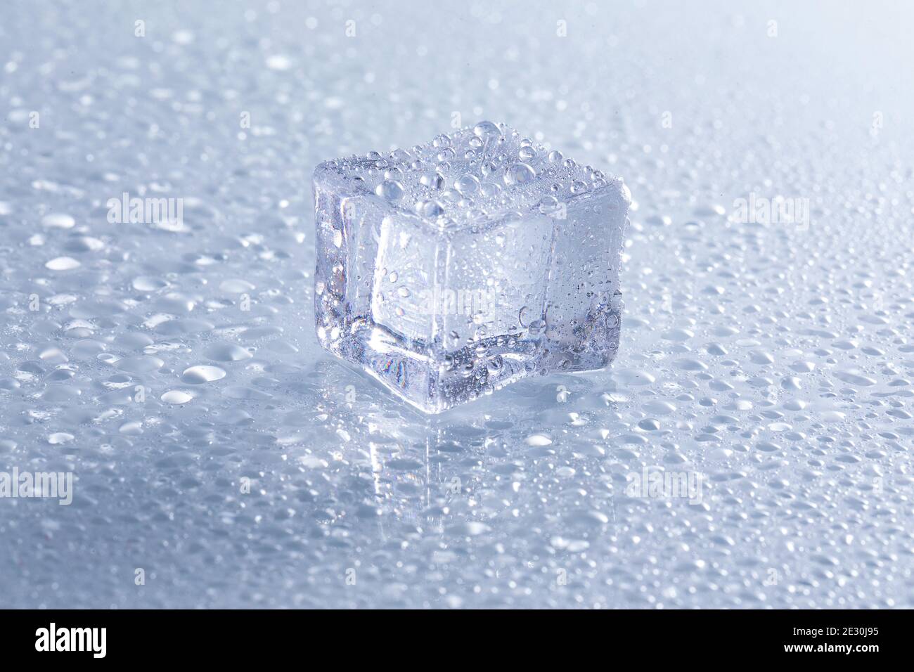 Selective focus shot of a melting ice cube on a wet surface Stock Photo ...