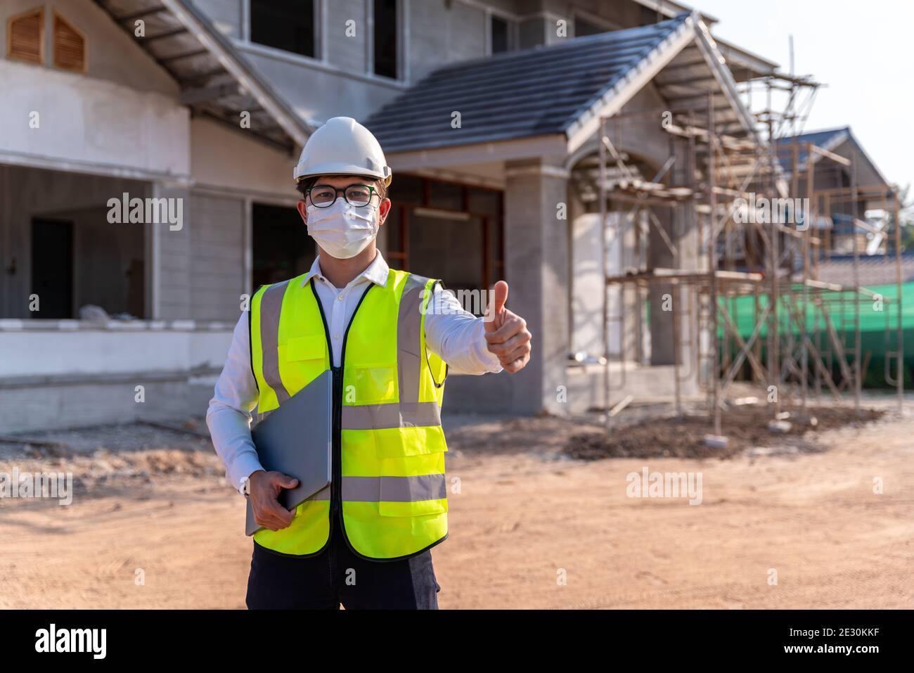 Portrait of Architect wearing a mask on a building construction site, Homebuilding Ideas and Prevention of Coronavirus Disease. Stock Photo