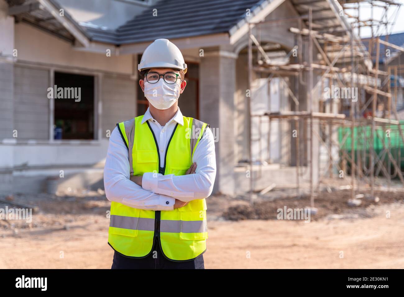 Portrait of Architect wearing a mask on a building construction site, Homebuilding Ideas and Prevention of Coronavirus Disease. Stock Photo