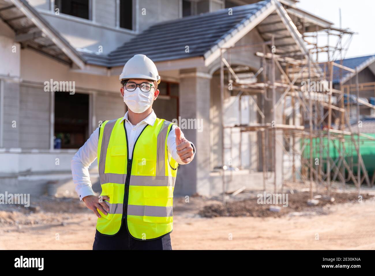 Portrait of Architect wearing a mask reassure on a building construction site, Homebuilding Ideas and Prevention of Coronavirus Disease. Stock Photo