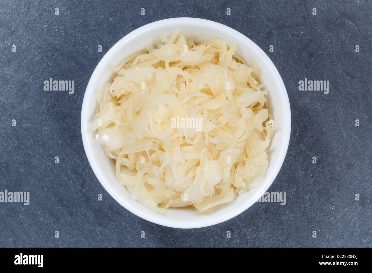 Sauerkraut coleslaw cabbage sliced from above bowl on a slate top view Stock Photo