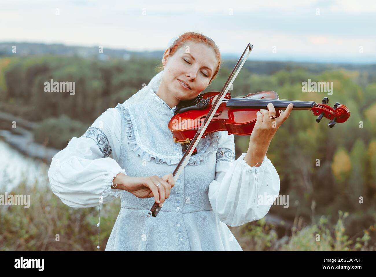 beautiful girl playing violin in white dress in forest Stock Photo - Alamy