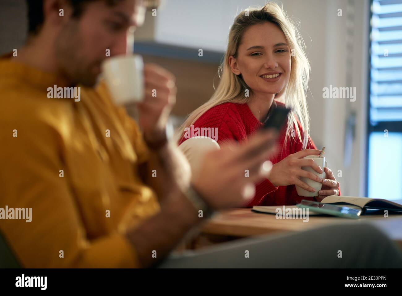 A young couple enjoying a morning routine in a relaxed atmosphere at the kitchen. Routine, relationship, together Stock Photo