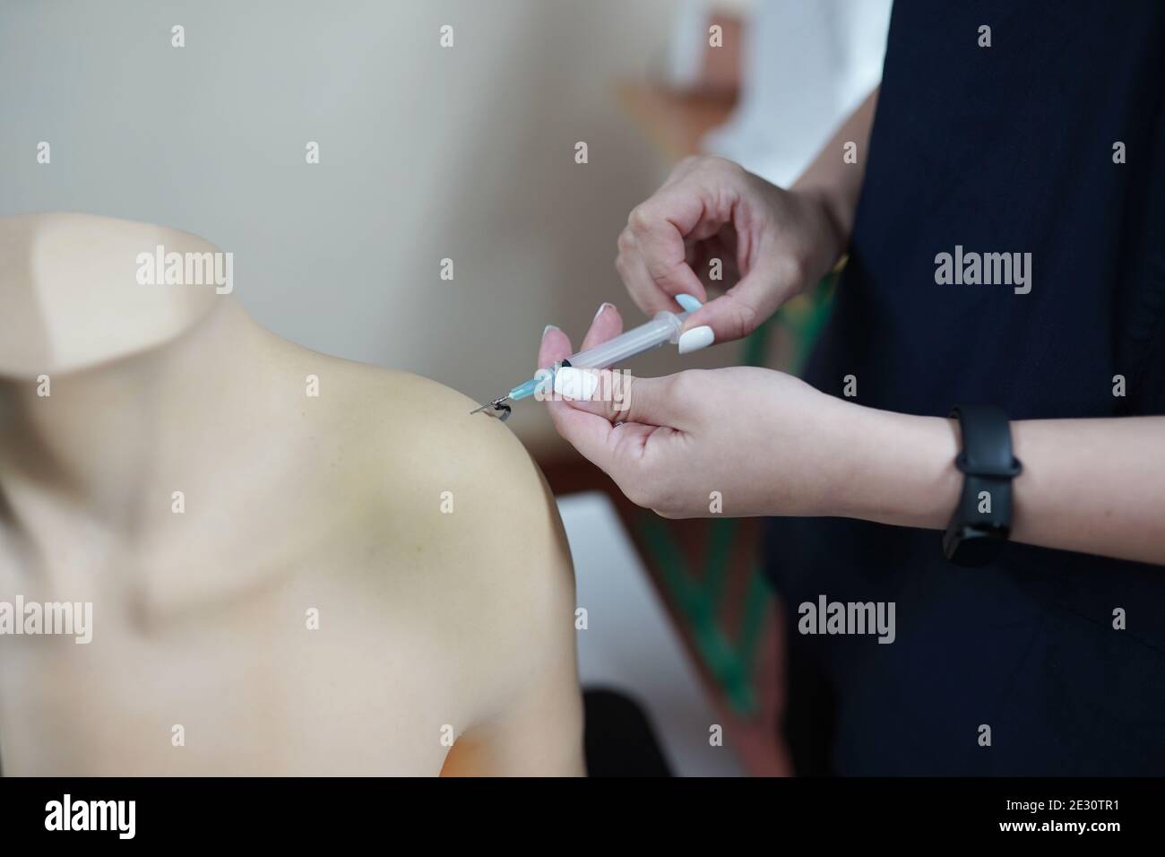 nurse wears gloves training injection with arm model for education at hospital or school of nursing Stock Photo
