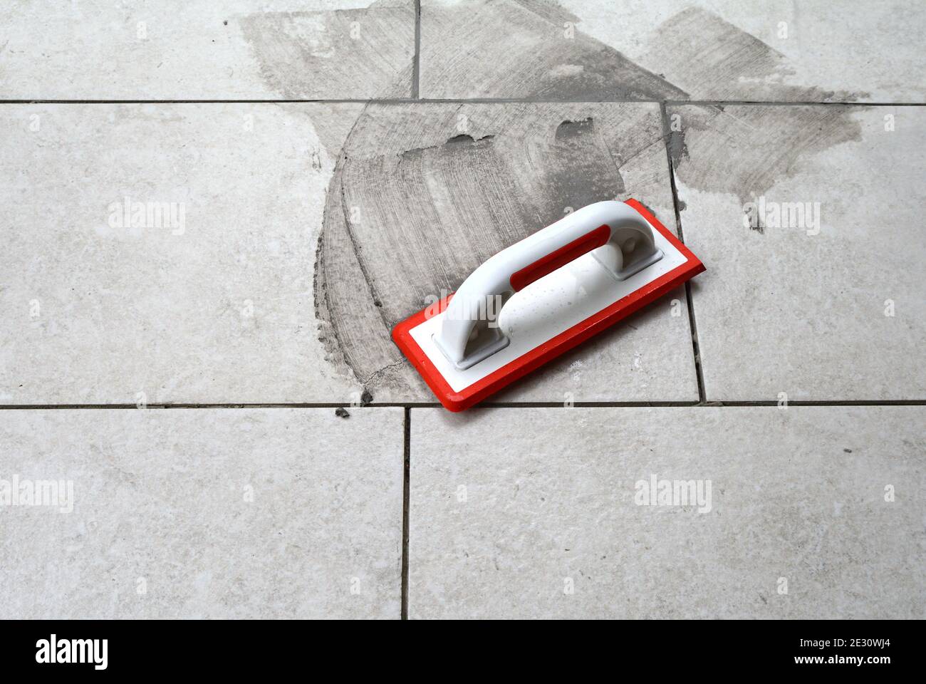 Grouting ceramic tiles. Filling the space between tiles using a rubber