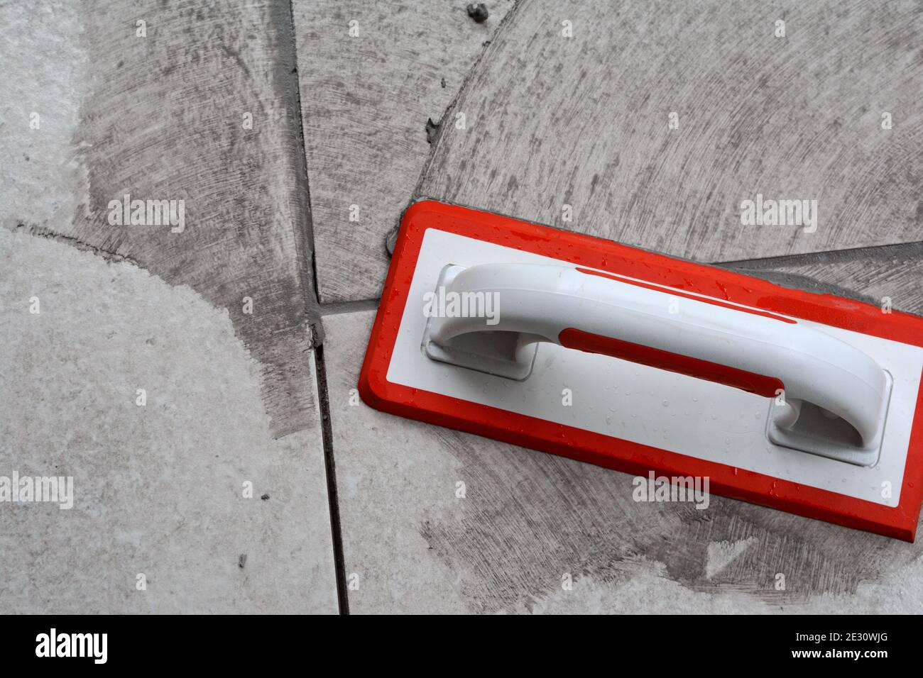 Grouting ceramic tiles. Filling the space between tiles using a rubber