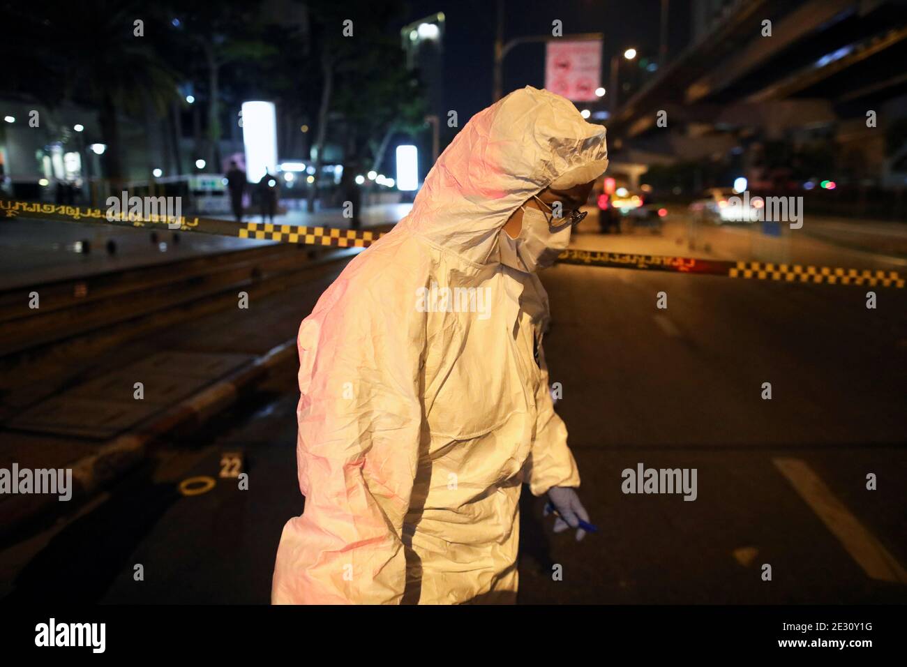 A police officer wearing PPE investigates at a blast site near a demonstration demanding to release the people arrested following the anti-government and reforming monarchy protests in Bangkok, Thailand, January 16, 2021. REUTERS/Soe Zeya Tun Stock Photo