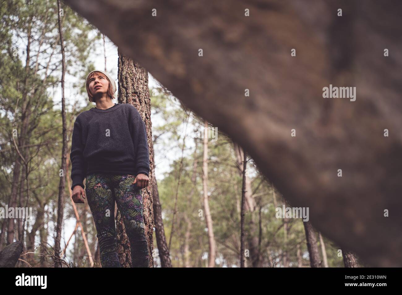 A female climber preparing to go bouldering on the rocks the forest of